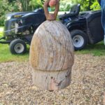 Solid wooden object in a cylindrical shape with metal rings both at the top and bottom, pretty heavy too.