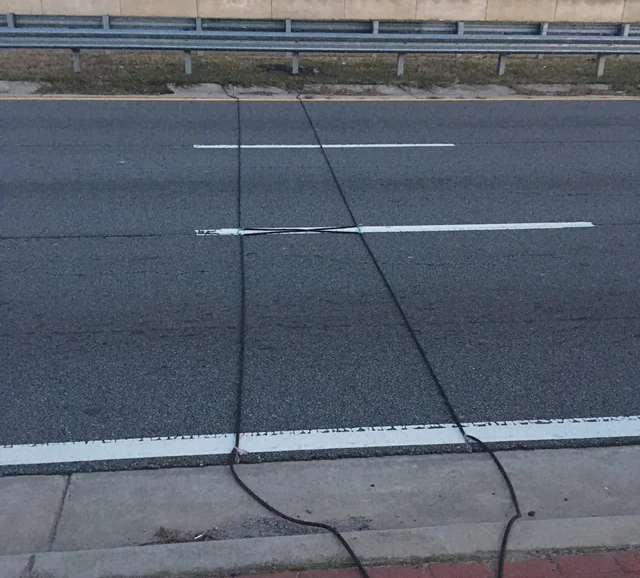 Here’s what those mysterious black cables on the road signify.