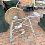 Can anyone identify this? I’m at a holiday cottage, and this is in the garden. It’s mostly metal, has a pedal attached to a large cog with a bolt above it, and looks very old