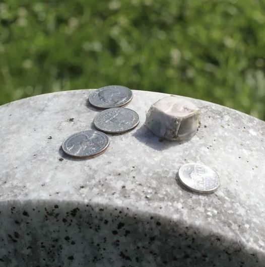 The purpose of leaving coins on gravestones