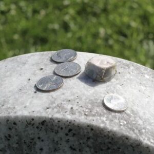 The purpose of leaving coins on gravestones